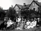 Ungdomsfest hos Albanus Johansson. Han står i bakgrunden mellan buskarna. Liggande längst fram: ?, Karin Andersson, ?, Sten Bresell, Silvergärde, Anders Gunnarsson, Skälstorp, Ester Johansson, dotter till Albanus, ?, Herman Karlsson, Stenstorp,?, ?, ?, Hjalmar Johansson, son till Albanus. Bakre raden: ?, ?, Artur Svensson, Gallagärde, Signe Johansson, dotter till Albanus, Artur Johansson, Bonnaberg, Karl Andersson, Bråtagärde, ?, ?