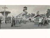 Tivoli som troligen var uppställt i samband med en större utställning i Halmstad. Till vänster en karusell, i mitten ett torn med rutschbana och i bakgrunden en berg-och-dal-bana.
