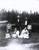 Foto av svåger Emil med söner Karl-Emil, Hugo och Vigo, döttrar Barbro, Tora, moster Gerda, mamma Tora och Inga-Lill, som ej vill vara med på kortet, pappa är fotograf (enligt bildtext i album).