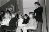 Ordföranden i svenska Unicef-kommittén Lisbeth Palme vid en sammankomst för Unicef i Fässbergsgymnasiets aula i Mölndal, slutet av 1980-talet eller början av 1990-talet. Framför Lisbeth sitter några barn.