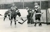 Ishockeyspelare i Mölndals IF spelar match. Fotografiet är möjligen taget vid Mölndals konstisbana vid Ågatan i Trädgården, Mölndal, ca 1970-1976.
