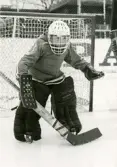 En ung ishockeymålvakt på ishockeyskolan. Fotografiet är taget vid Mölndals konstisbana vid Ågatan i Trädgården, Mölndal, ca 1970-1976.