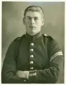 En ung man i uniform.
På baksidan text: 