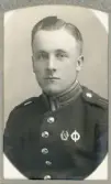 En ung man i uniform (m/95) med förtjänstmärken.
Bröstbild, halvprofil. Ateljéfoto.