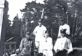 Foto av Ingrid Welander (f. Lagerholm) med ett gäng uniformerade män. Bildtext i album: 