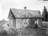 En kvinna vid en stuga