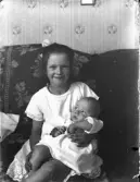 Flicka med bebis i famnen