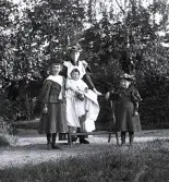 Foto av en kvinna, troligen barnflicka, med barnen Lagerholm fr v Ingrid, Harald och Ellen.