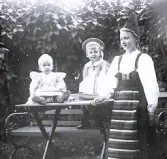 Foto av barnen Lagerholm fr v. Ellen, Harald och Ingrid i trädgården.