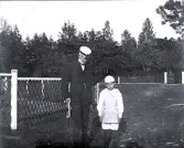 Foto av en man i kavaj och hatt samt en pojke.