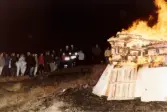 Firande på Störtfjället i Mölndal under valborgsmässoaftonen. Människor har samlats vid valborgsmässoelden. Cirka 1980-tal.
