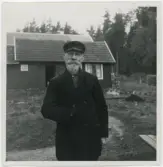 Porträtt på en man framför ett hus.