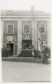 Tegnérfesten 7 september 1926, i samband med avtäckandet av Tegnérstoden vid dåv. stifts- och landsbiblioteket (numera Karolinerhuset). 
Landshövding August Beskow i talarstolen. Till vänster syns en del av stadens honoratiores, i dörröppningen syns arkitekten m.m. Paul Boberg. Till höger skymtar en fanborg med studenter, tillsammans med några nyfikna skolpojkar.