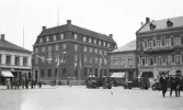 Göteborgs Bank, vid Stora torg i Halmstad.
Vid sidorna syns flera butiker, bl a Kalbs guldsmedsaffär.