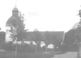 S:t Laurentii kyrka med delar av S:t Laurentiiparken.  Enl. uppgift i album, bild av Anna D.  Ytterligare en kopia finns, 00352:2 från Falkmanska samlingen, se post 00014.    Ur kyrkoprotokoll: 18980825 beslutades att vapenhuset skulle bort, arbetet skulle utföras av kyrkovaktmästare Nilsson som erhöll virket som ersättning.(C.E.)