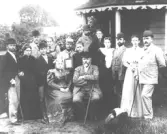 Släktträff i den Hallbergs familjen 1895.  Bilden är tagen 1895 i Harry Hallbergs trädgård Storgatan 21. Det året var Karl hemma från Amerika. Lusthuset syns på bilden. Det lät Anders H sedan flytta till sin trädgård ner mot Ågatan, granne med Hvitans trädgård. Jarl, min sagesman minnes lusthuset.  Personer på bilden: Sittande fr.v. fru Hilldegard H f. Silvén, handl. J.P. H. - Per Johan Simeon f. 1838 d. 1902, J.P. hade tio barn med sin första fru f. Hedenberg.Alla utom tre av dem finns med.  Stående fr.v. Karl reste till Amerika, gift med en amerikanska kate, hans fru. Anders H. f. 1875 d. 1949, här 20-årig, Robert H. chaufför, lantbrukare, Hilda hans första fru, ett porträtt med den broder Emil som var i Amerika. fru Berta H. född Cytreus, Gustaf H. klädeshandlande. Byggde sitt hus Storgatan 25 1910. Hanna H. född Nordblom, Harry H. handlande med livsmedel.  Andra raden stående fr.v. Elof Laurell på Öströö, Hanna L. Född Hallberg, Algot H. på Munkagård, Lotten H. F. Lönndahl. deras son Figge 