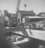 Bilderna kommer från ett arkiv på AB Falcon. På bilderna lastas en båt med kartonger märkta   