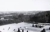 Foto av en del av en slottspark, kanske slottet Versailles, med vy över en bebyggelse, 1924-25.