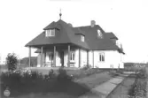Villa Olsgården. Bostadshus i 1 1/2 vån. uppfört 1923 för Gerda Olsson efter ritningar av Hakon Ahlberg. Gerda Olsson drev under många år stadshotellet vid Rådhustorget. Villa Olsgården har utformats som en lekfull parafras på 1700-talslustslottet Liselund på den danska ön Mön. Den fransk-klassiska trädgården är anlagd av Norrvikens trädgårds skapare , Rudolf Abelin.