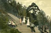 Kolorerat vykort med motiv från uppgången till stadsparken i Jönköping. Skickat 1906-12-29.