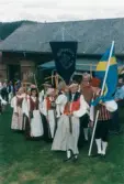 Spelmansstämma på hembygdsgården Börjesgården i Hällesåker, Lindome, i Mölndals kommun den 8 juli 2000. Hällesåkers folkdanslag. Männen bär på liar och kvinnorna bär på räfsor.