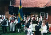 Spelmansstämma på hembygdsgården Börjesgården i Hällesåker, Lindome, i Mölndals kommun den 8 juli 2000. Hällesåkers folkdanslag. Männen bär på liar och kvinnorna bär på räfsor.