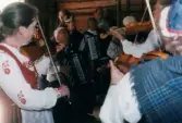 Spelmansstämma på hembygdsgården Börjesgården i Hällesåker, Lindome, i Mölndals kommun den 8 juli 2000. Män och kvinnor som spelar på sina instrument.