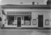 Almqvist övertog den 1 april 1930 Berta Johanssons ateljé på Stationsgatan 1. Affären flyttades till samma hus den 1 okt 1932.   Ur Textkompletering, Erik Kylén, 1991