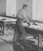 Garveriarbetare vid Läderfabriken, skrapar en hud ren med verktyget kallat skärdegen.