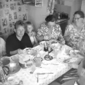 Interiör från badstuga med måtten 3,15x3,15 m.  Fr.v. ägaren Carl-Gustav Bengtsson, hans dotter. I bakgrunden syns tidtypisk fondtapet, stringhylla på väggen till pentryt.