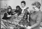 Greta Nilsson-Bergström i sin syateljé, hos Bigges, 3:e vån, Fbg.   Innehade damskrädderi 1945-1975 i Fbg.  Fotot tagit för en artikel i tidningen, då hennes syateljé 25-års jubilerade.  Fr.v. SONNHAG Margareta, har syateljé i Halmstad. STENSSON Majlis, g Fritzson  JOHANSSON Marianne Inger  NILSSON Greta.  De två förstnämnda tog gesällprov hos Greta.