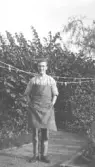 Karl-Gustaf Rosén, son till skomakare Edvin Rosén. fotot tagit i familjens trädgård. K-G har skomakareförkläde på sig.