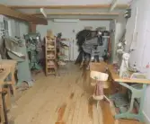 Foto över basutställningen av stadsmiljön på museets andra plan. Fd Skomakare-arbetare C-G Bengtsson arbetar i skofabriken.