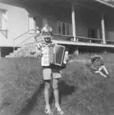 Text i album. Jag på Hackarpskolonin med mitt första dragspel juni 1955 togs kortet.