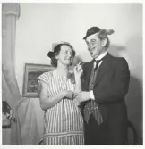 Text på baksida av foto. Stina på maskerad hos Marianne o B-G Gilmark.  Förklädet som Stina bär finns i museets samling.