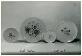Fat och assiett från Bo Fajans, formgivna av bland annat Allan Ebeling, tidigt 1900-tal. Dekorer Flora och L.K.
