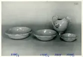 Tre skålar och en kanna med en målad fågel från Bo Fajans, formgivare Eva Jancke-Björk, 1900-talets mitt.