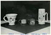 Bägare, muggar samt en vas från Bo Fajans, formgivan av Allan Ebeling och Eva Jancke-Björk, 1900-talets mitt.