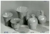 Bägare och krus med ristad vit dekor från Bo Fajans, formgivare Eva Jancke-Björk, 1900-talets mitt.