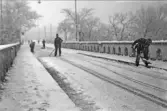 Män röjer snö på Tullbron