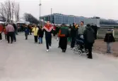 En idrottare springer vid travbanan med den olympiska elden i samband med Olympiatravet på Åbytravet i Åby, Mölndal, år 1998.