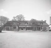 Boktryckare Davidssons fastighet, kv. Elden södra nr 6, Växjö.
Vy från nuv. Oxtorget mot nordväst. På fastighetens skyltar kan man läsa följande fr. v. till h.: 