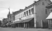 En affärsfastighet längs Storgatan (kv, Klostret) i Växjö, med Hemslöjden, Ivan Cronqvists skoaffär och A.B. Wäxjö Textilkompani. 
I bakgrunden syns bl a den s.k. Feukska fastigheten med Oscar Carlssons uraffär m.m.