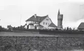 En större privatvilla i utkanten av ett villaområde i Landskrona. I bakgrunden syns det dåvarande vattentornet, uppfört 1904.