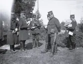 Foto av en grupp militärer som är ute på fältövningar. Text i album: 