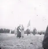 Foto av militärer och en skara med människor som åskådare, kanske en fältövning ska börja.