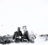 Foto av militärer som är ute på fältövningar en lantlig bakgrund. Text i album: 