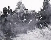 Foto av en grupp militärer som tar en fikapaus från fältövningarna. Text i album: 