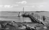 Getteröbåten vid brygga på Getterön, där en klunga passagerare väntar på att få stiga ombord. Vykortsförlag: Allan Lundgrens Bokhandel, Varberg.