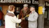 Medlemmar i fotbollsföreningen Jitex BK delar ut blommor till folk i Mölndals centrum i mars 1992. Två äldre herrar får blommor vid SEB på Brogatan.